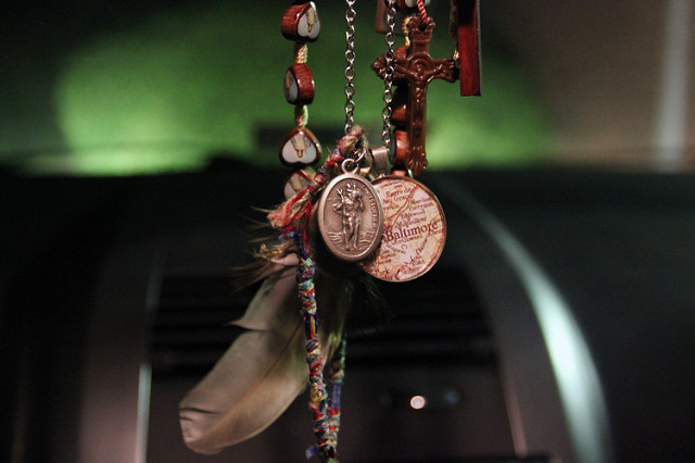 A medallion depicting Saint Christopher – the patron saint of travellers – hangs from the rear view mirror of a car.